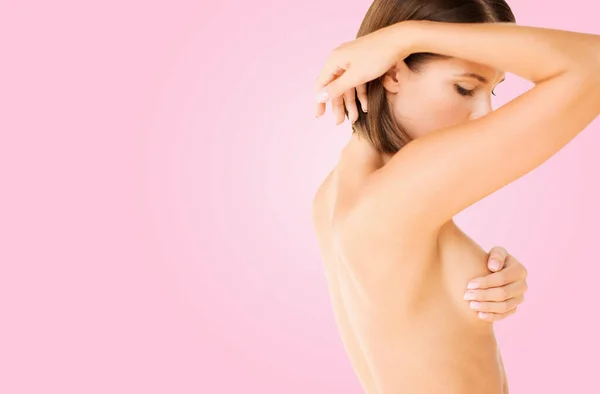 Νεαρή γυναίκα που ελέγχει το στήθος για σημάδια καρκίνου — Φωτογραφία Αρχείου
