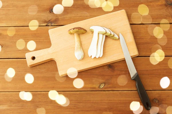 Edible mushrooms, kitchen knife and cutting board — Stock Photo, Image