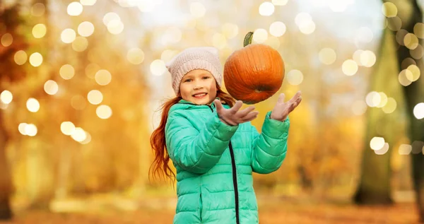 Chica feliz jugando con la calabaza en el parque de otoño — Foto de Stock