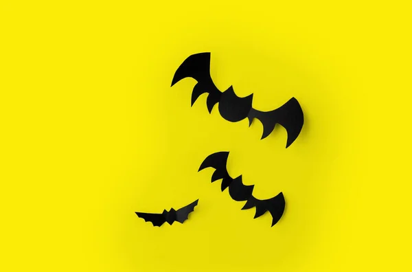 Flock of black paper bats over yellow background — Stock Photo, Image
