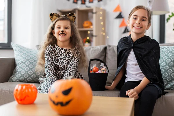 Flickor i halloween kostymer med godis hemma — Stockfoto