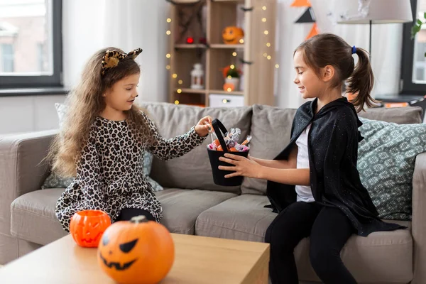 Flickor i halloween kostymer med godis hemma — Stockfoto