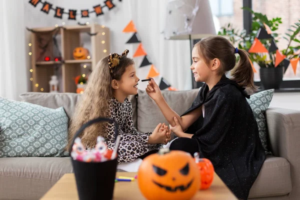 Девушки рисуют лица на Хэллоуин дома — стоковое фото