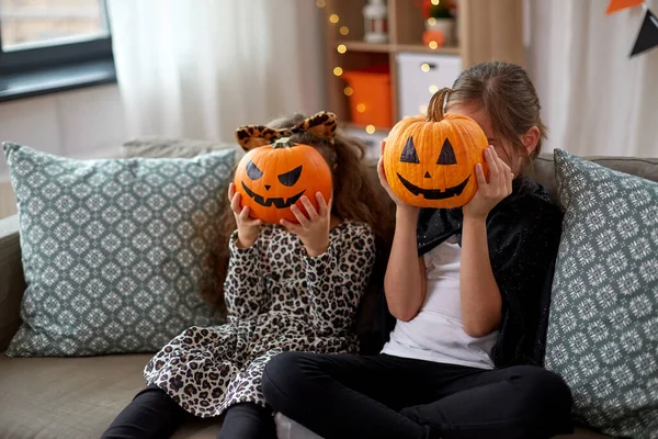 Девушки в костюмах на Хэллоуин с тыквами дома — стоковое фото