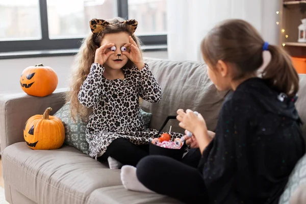 Meninas em trajes de Halloween com doces em casa — Fotografia de Stock