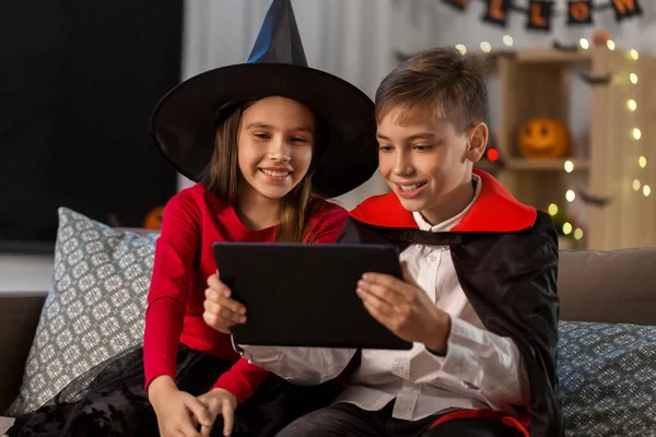 Дети в костюмах на Хэллоуин с планшетным ПК дома — стоковое фото