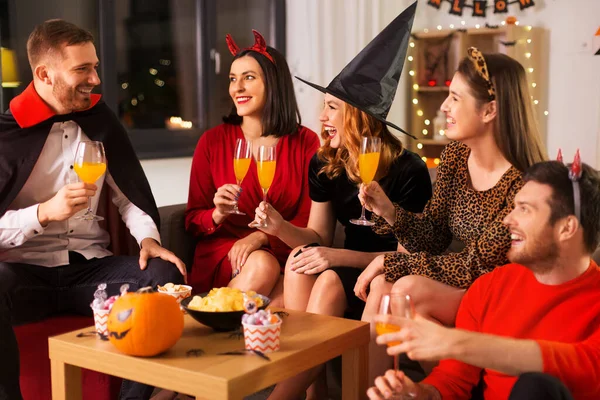 Счастливые друзья в костюмах Хэллоуина на домашней вечеринке — стоковое фото