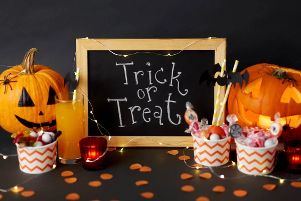 Pumpkins, candies and halloween decorations — Stock Photo, Image