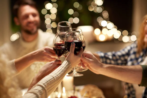 Amigos felices bebiendo vino tinto en la fiesta de Navidad —  Fotos de Stock