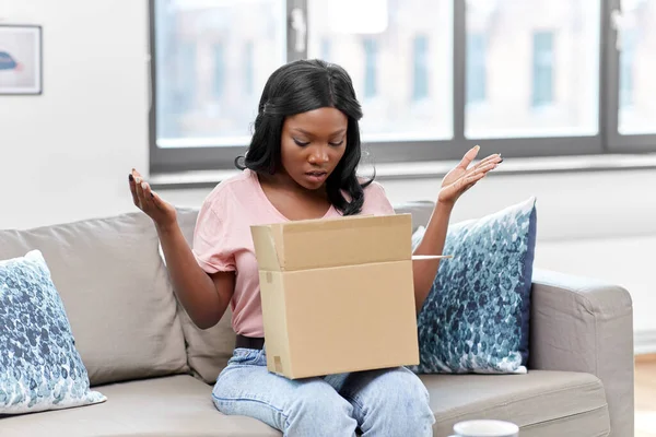 Üzgün, Afro-Amerikalı kadın. Paket kutusu evde. — Stok fotoğraf