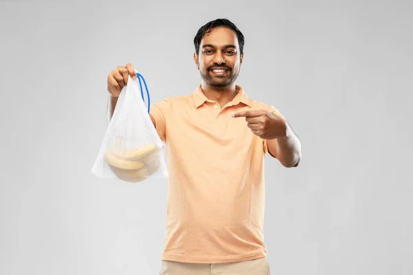 Uomo felice in possesso di borsa riutilizzabile stringa con banane — Foto Stock