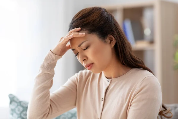 Doente asiático mulher tendo dor de cabeça em casa — Fotografia de Stock