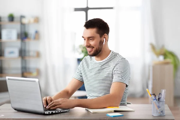 Uomo con laptop e auricolari a casa ufficio — Foto Stock