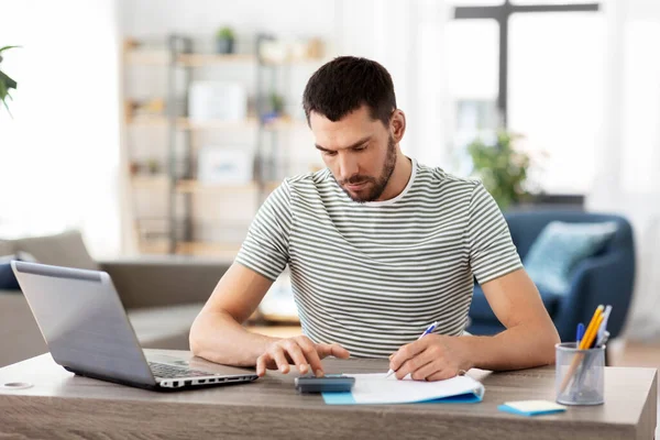 Man med filer och miniräknare arbetar på hemmakontoret — Stockfoto