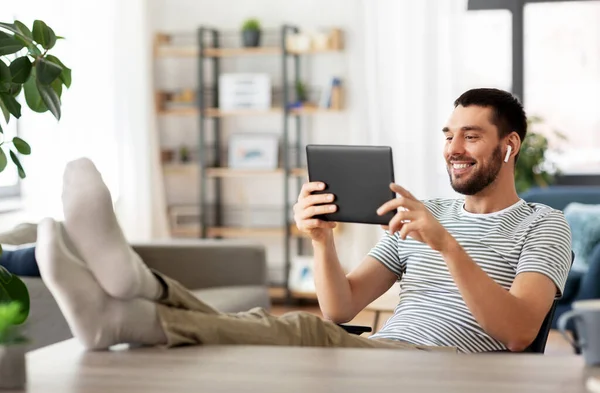 Homme heureux avec tablette PC et écouteurs à la maison — Photo