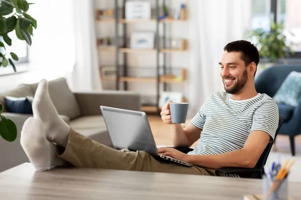 Hombre feliz con el ordenador portátil beber café en casa — Foto de Stock