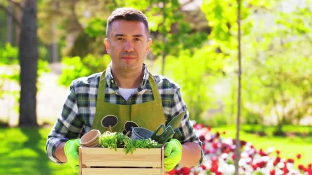 Happy man with tools in box at summer garden — Stock Video