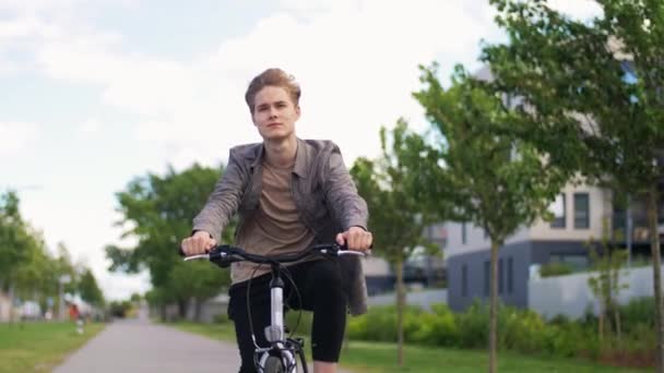 Young man riding bicycle on city street — Stock Video