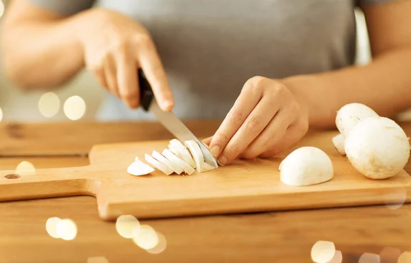 Kobieta cięcia champignons nożem na pokładzie — Zdjęcie stockowe