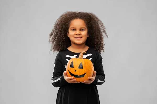 Mädchen im schwarzen Halloween-Kleid mit Jack-o-Laterne — Stockfoto