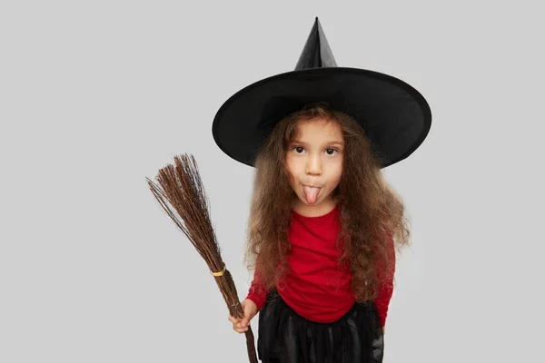 Menina em chapéu de bruxa preta com vassoura no dia das bruxas — Fotografia de Stock