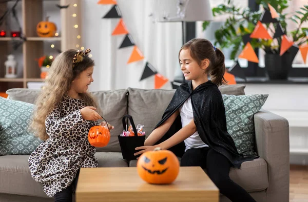 Meninas em trajes de Halloween com doces em casa — Fotografia de Stock