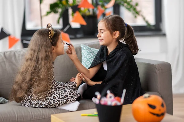 Meisjes doen gezicht schilderen op halloween thuis — Stockfoto