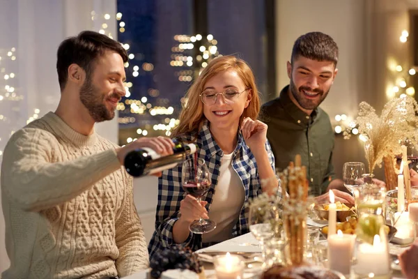 Happy friends with red wine at christmas party — Stock Photo, Image
