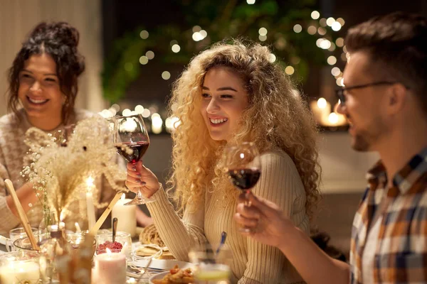 Happy friends drinking red wine at christmas party — Stock Photo, Image