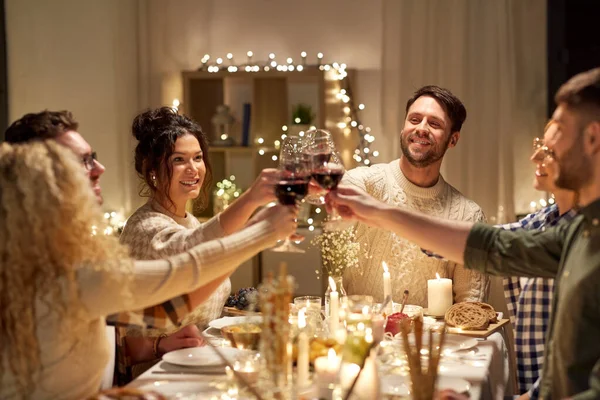 Glückliche Freunde, die auf der Weihnachtsfeier Rotwein trinken — Stockfoto