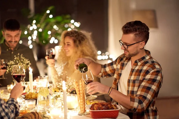 Mann schenkt bei Dinnerparty Rotwein ins Glas ein — Stockfoto