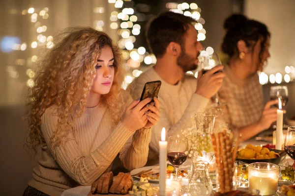 Женщина со смартфоном на вечеринке с друзьями — стоковое фото