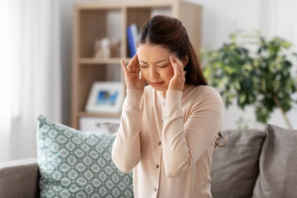 Beteg ázsiai nő, akinek fejfájás otthon — Stock Fotó