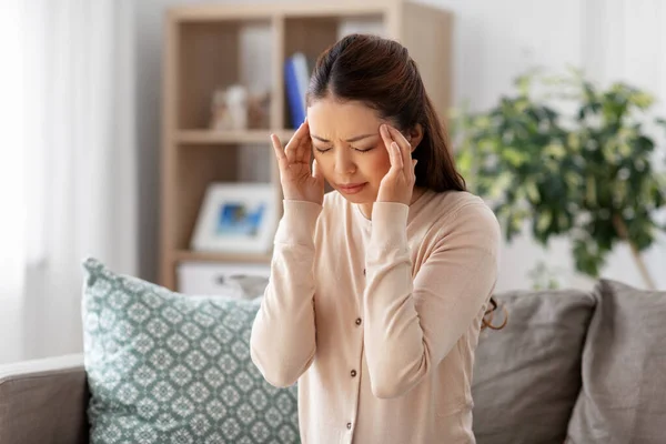 Zieke aziatische vrouw met hoofdpijn thuis — Stockfoto