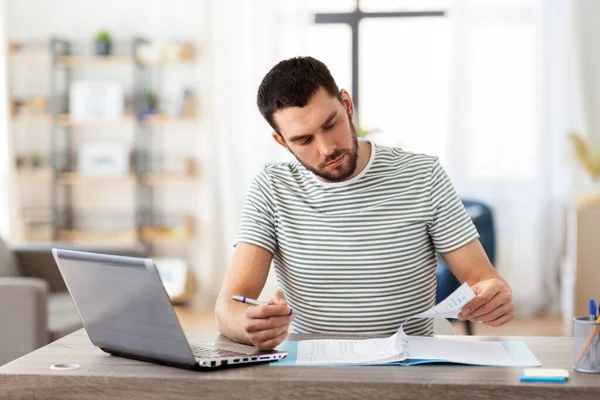 Uomo con documenti e laptop che lavora a casa ufficio — Foto Stock