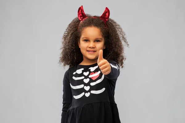 Girl in black dress and devils horns on halloween — Stock Photo, Image