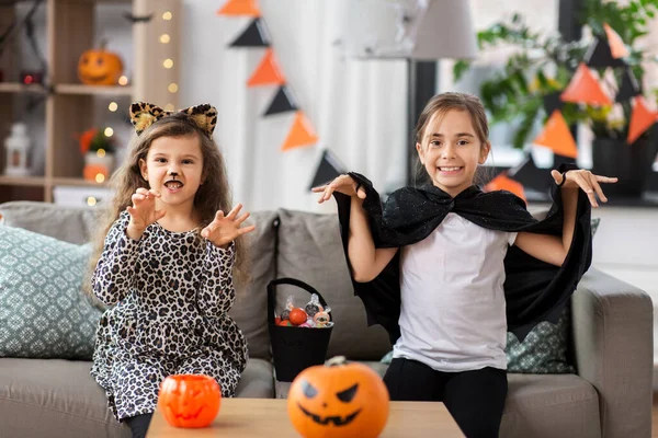 Girls in halloween costumes with candies at home — Stock Photo, Image