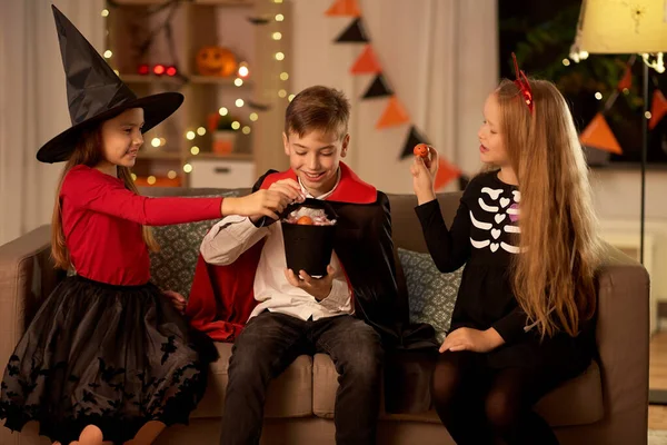 Barn i halloween kostymer dela godis hemma — Stockfoto