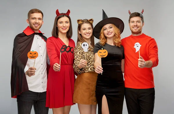 Vänner i halloween kostymer med parti rekvisita — Stockfoto