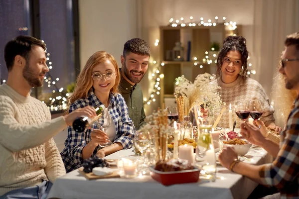 Amis heureux avec du vin rouge à la fête de Noël — Photo