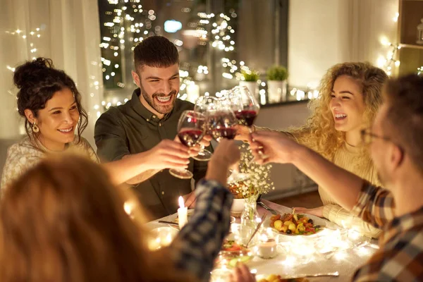 Amis heureux boire du vin rouge à la fête de Noël — Photo