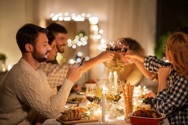 友達と食事会でスマートフォンを持つ男 — ストック写真