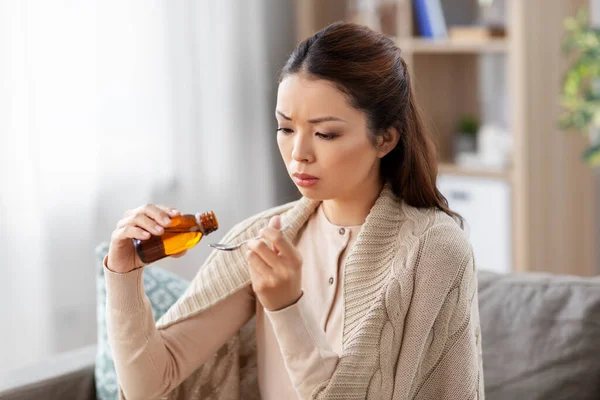 Больная азиатка, принимающая лекарства дома — стоковое фото