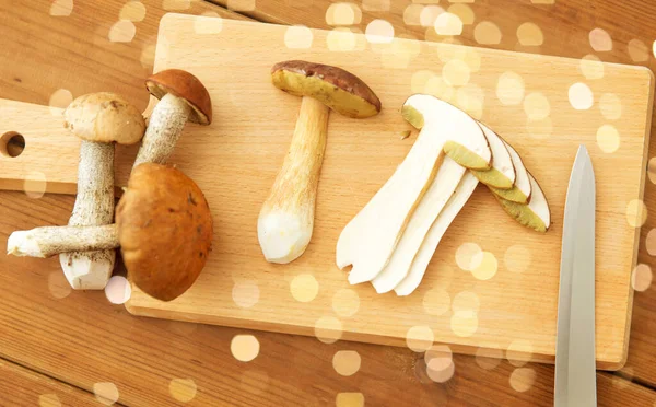 Cogumelos comestíveis, faca de cozinha e tábua de corte — Fotografia de Stock