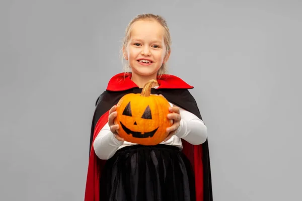 Girl in halloween costume of dracula with pumpkin — Stock Photo, Image