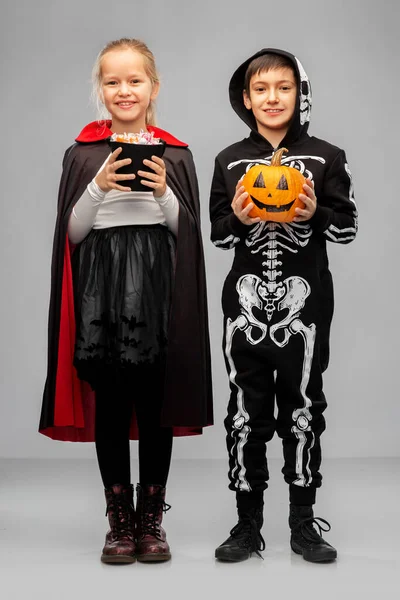 Happy children in halloween costumes with candies — Stock Photo, Image