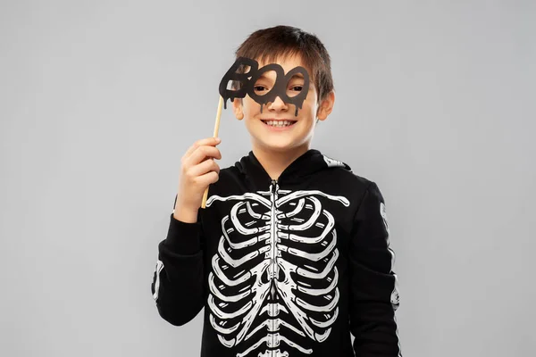 Jongen in halloween kostuum van skelet met rekwisieten — Stockfoto