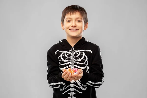 Jongen in halloween kostuum van skelet met snoepjes — Stockfoto