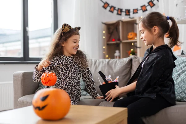 Flickor i halloween kostymer med godis hemma — Stockfoto