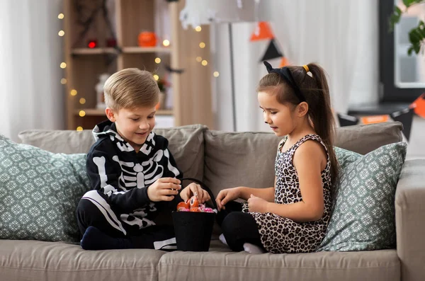 Ungar i halloween kostymer med godis hemma — Stockfoto